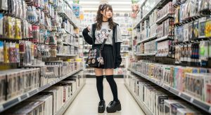 \<img src="h3\_surugaya.jpg" alt="駿河屋のようなホビーショップで商品を探すミニスカートの女性"\>
