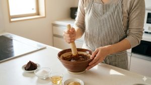 自宅のキッチンで、赤味噌、砂糖、みりん、だし粉末を混ぜて「ジェネリック・つけてみそ」を作る日本人女性。再現レシピの工程を解説。